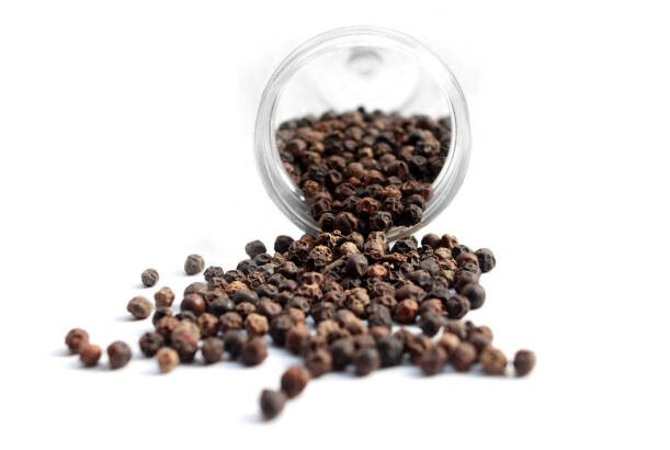 Black pepper background. Black pepper is a flowering vine in the family Piperaceae, cultivated for its fruit, known as a peppercorn, which is usually dried and used as a spice and seasoning. When fresh and fully mature, the fruit is about 5 mm in diameter, dark red, and contains a single seed, like all drupes.