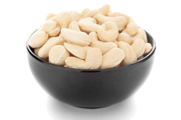 Close-up Organic dry fruit cashew nut (Anacardium occidentale)  in black ceramic  bowl on white background