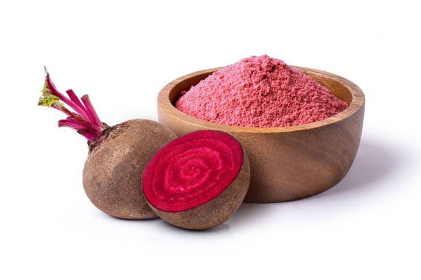 Beetroot (beet root) powder in wooden bowl with fresh fruit isolated on white background.