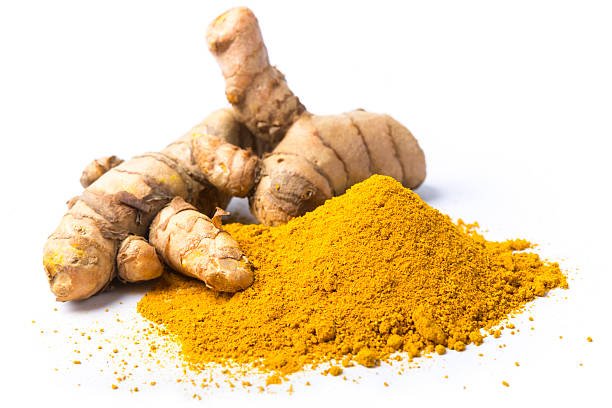 Close up view of fresh turmeric powdered heap with some turmeric plant, elements isolated on white.