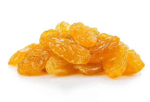 Yellow raisins close-up isolated on a white background.