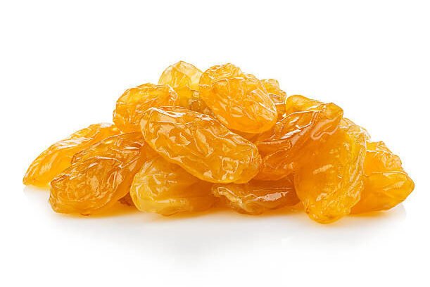 Yellow raisins close-up isolated on a white background.